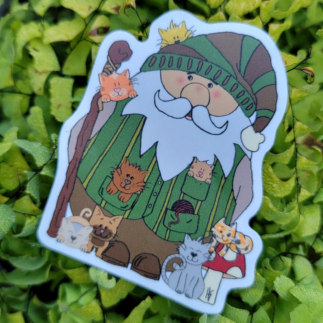 a gnome with a stick and a vest with 8 cats around him